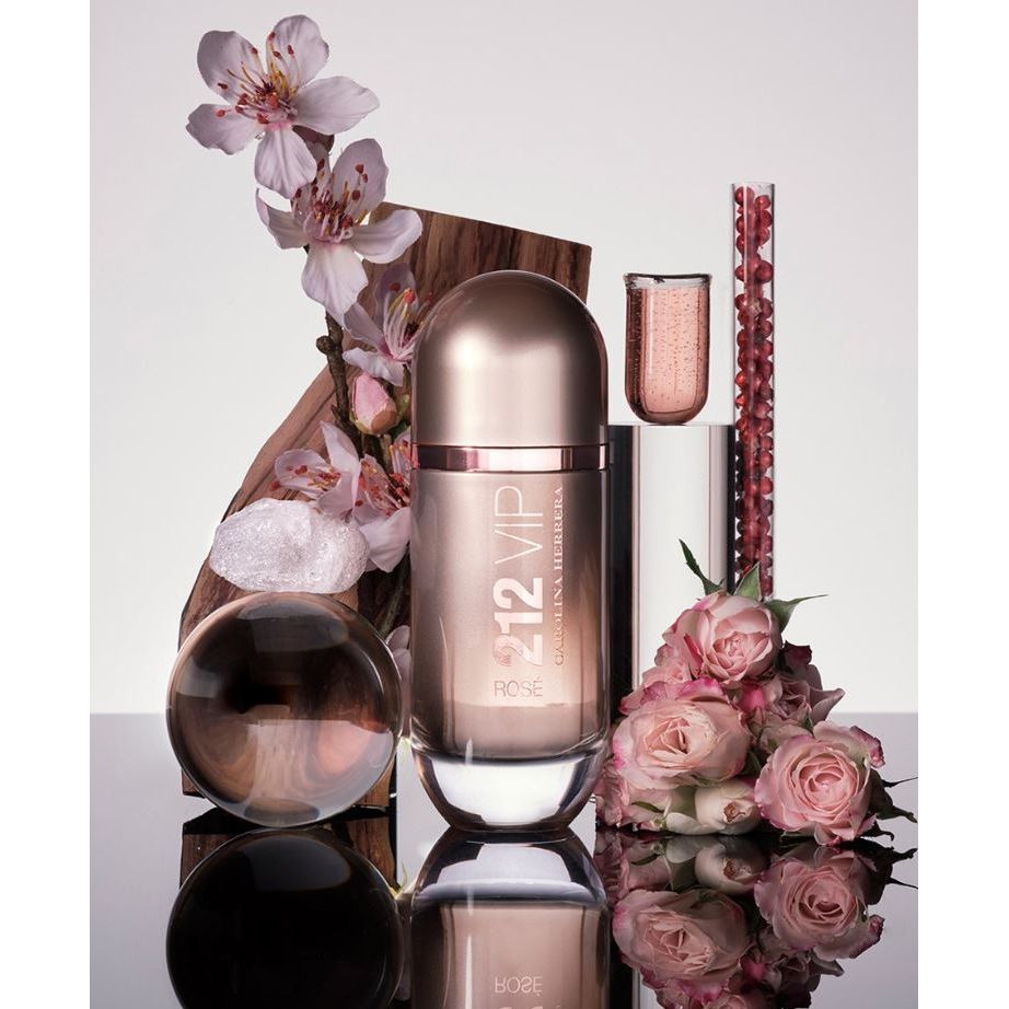 Carolina Herrera 212 VIP Rose perfume bottle with pink flowers and beauty elements