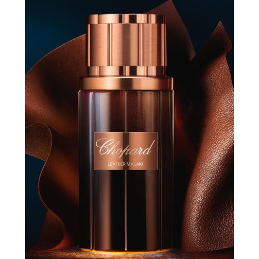 Chopard Leather Malaki perfume bottle with metallic bronze cap and textured leather backdrop
