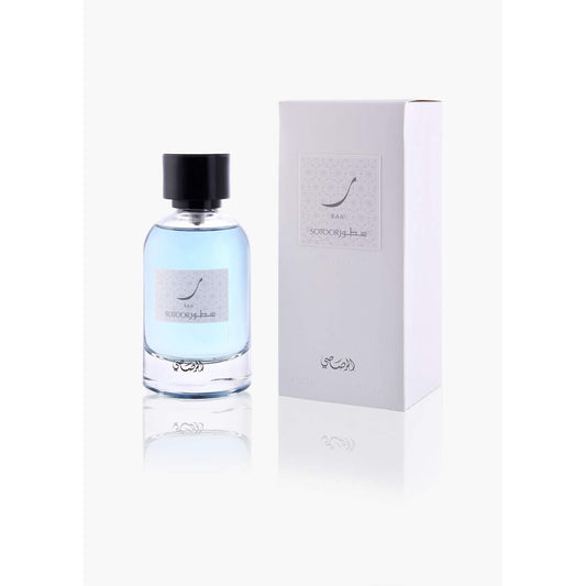 Clear glass perfume bottle with blue liquid and black cap beside white box, SOTOOR RAA fragrance.