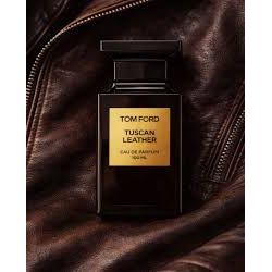 Tom Ford Tuscan Leather Eau de Parfum bottle on brown leather jacket, luxury fragrance