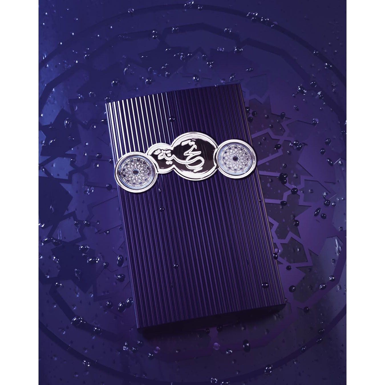Luxury purple perfume box with ornate silver emblem, featuring Arabic script and intricate designs on a geometric background.