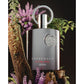 Luxury Supremacy perfume by AFNAN with metallic finish, surrounded by purple flowers and greenery