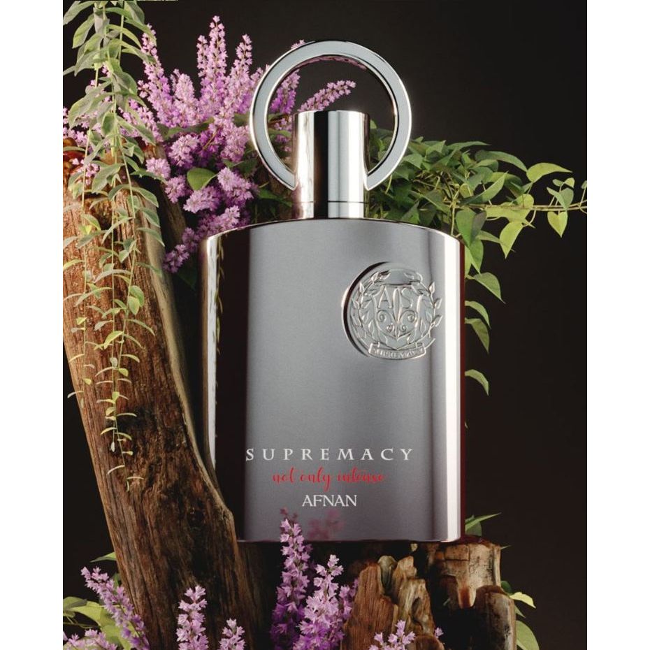 Luxury Supremacy perfume by AFNAN with metallic finish, surrounded by purple flowers and greenery