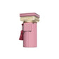 Pink luxury perfume bottle with gold accents, tassel, and pillar-inspired design