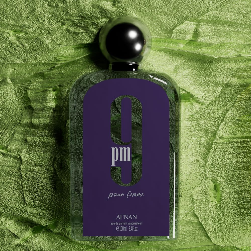 Afnan 9 PM Pour Femme perfume bottle with purple label on green textured background