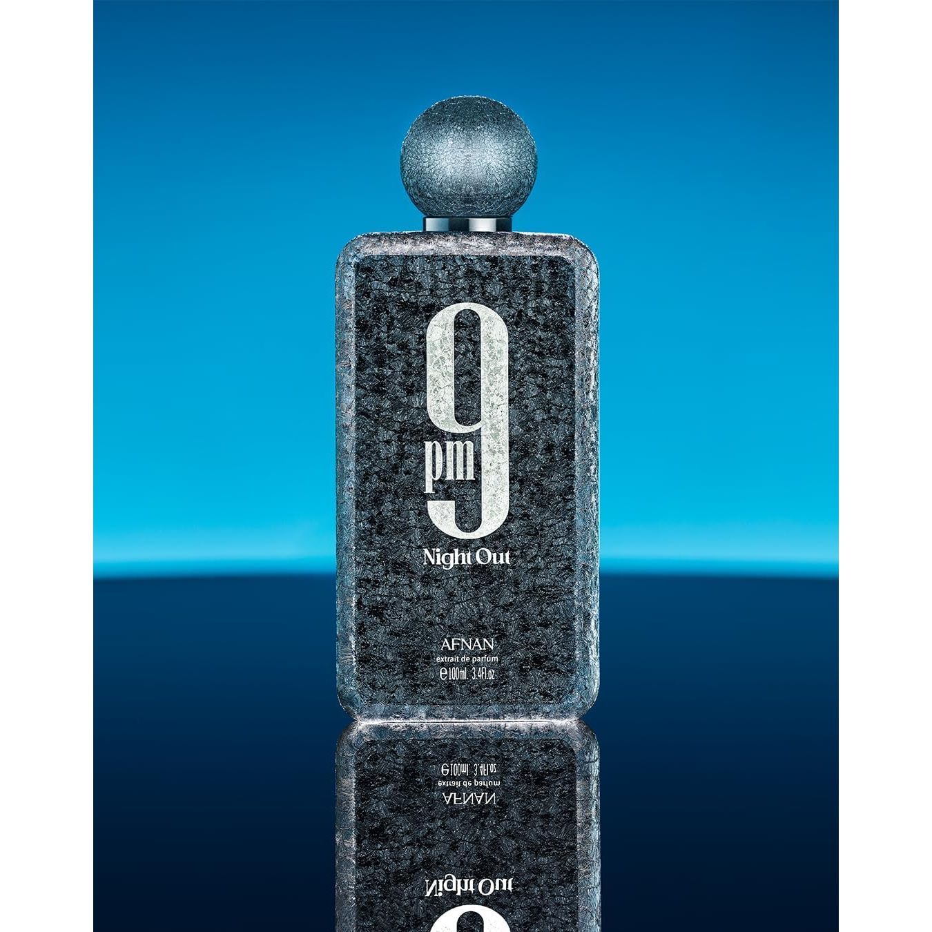 Afnan 9pm Night Out textured perfume bottle on blue gradient background.