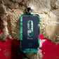 Afnan 9am Dive perfume bottle with blue-green glass and metallic cap on gold textured background