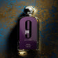 Afnan 9pm pour femme perfume bottle with metallic cap on textured gold and blue background.