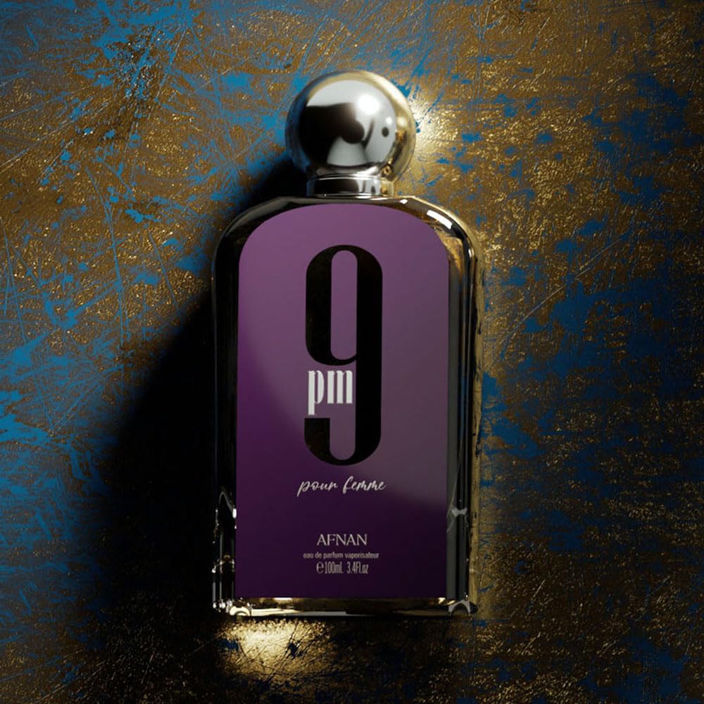 Afnan 9pm pour femme perfume bottle with metallic cap on textured gold and blue background.