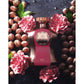 Luxury perfume bottle with rose gold accents, surrounded by pink flowers and nuts