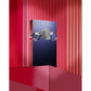 Luxury perfume bottle with blue crystal accents on red display, featuring Arabic script design