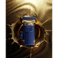 Luxury blue and gold perfume bottle with tassel on gold splash background, premium fragrance