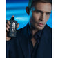 Man in navy suit holding 9pm Night Out perfume bottle against blue background