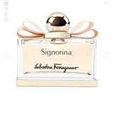 Clear glass bottle of Signorina Eleganza Eau de Parfum with gold cap and pink ribbon detail