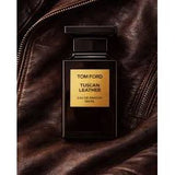 Tom Ford Tuscan Leather Eau de Parfum bottle on brown leather jacket, luxury fragrance